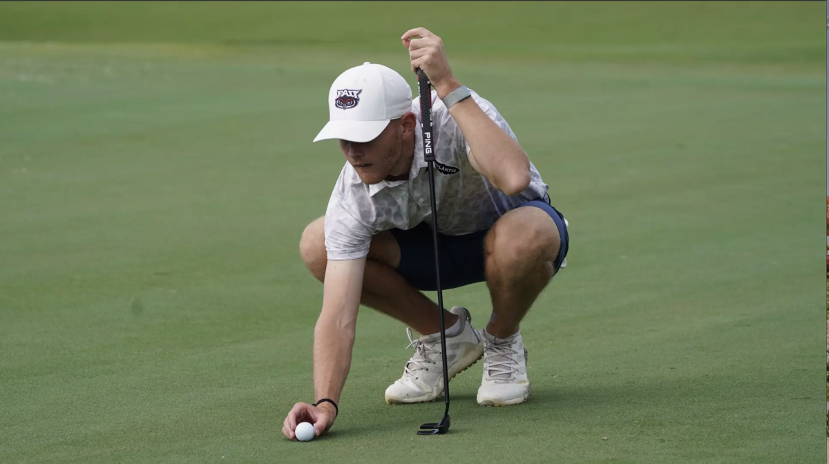 Jake Hibbert lining up a put in a golf tournament.